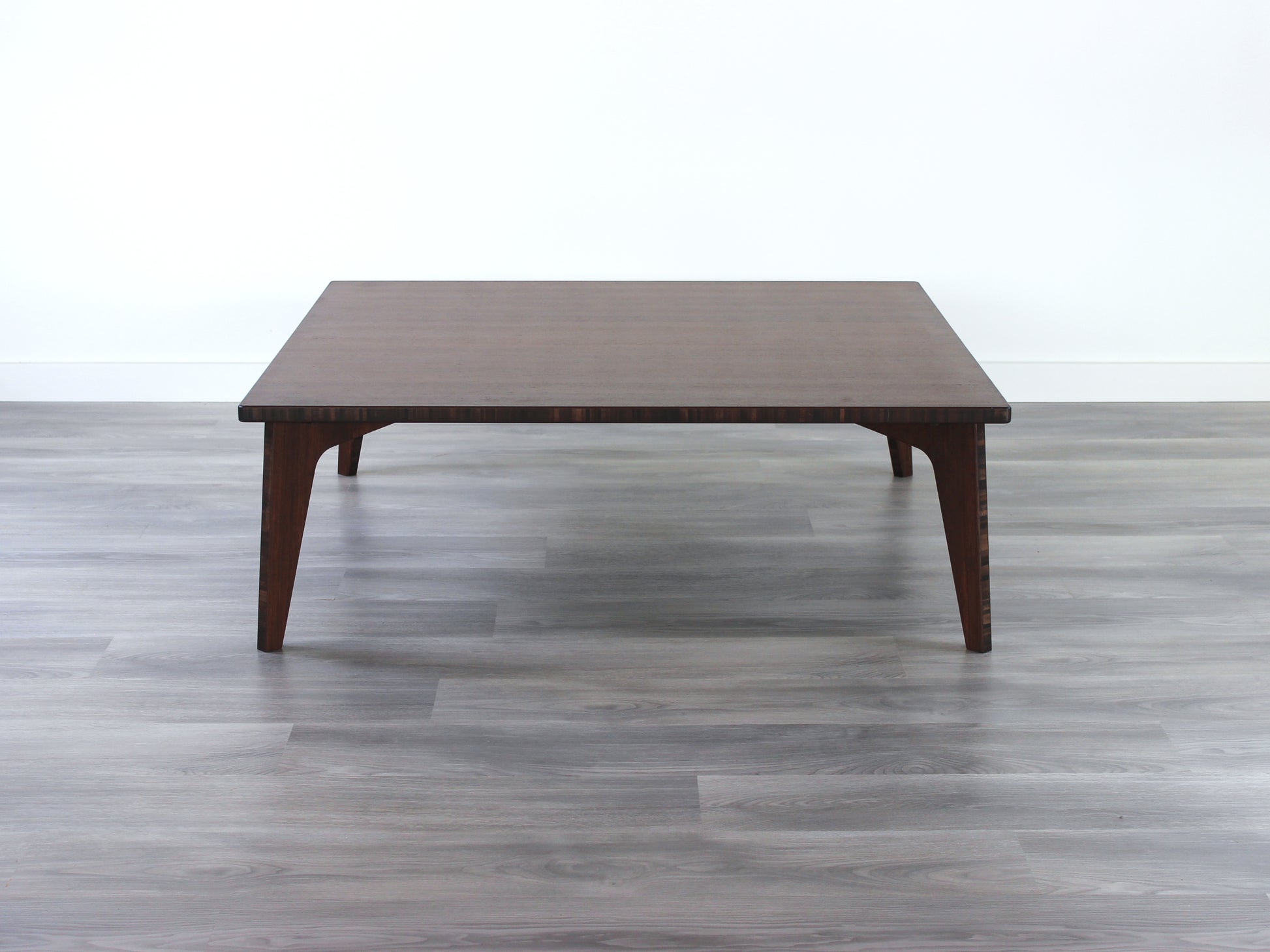 Large square floor table in bamboo with a walnut color finish, featuring a Japandi style design, set on a grey floor with a white background. A small black pottery vessel sets on top.

Square low table 
japanese furniture
japanese low table
low coffee table
low dining table
low table
mid century
minimalist
minimalist table
modern
chabudai