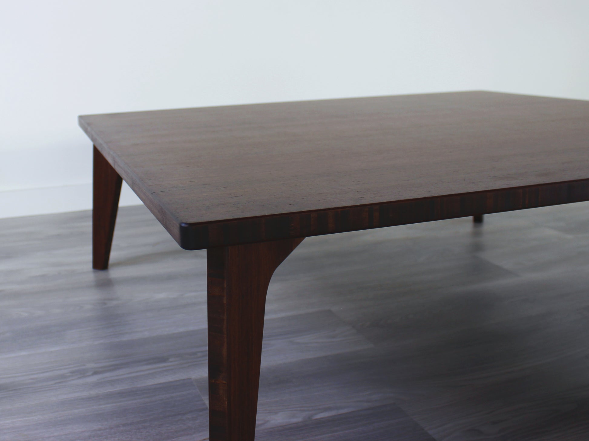 Large square floor table in bamboo with a walnut color finish, featuring a Japandi style design, set on a grey floor with a white background. A small black pottery vessel sets on top.

Square low table 
japanese furniture
japanese low table
low coffee table
low dining table
low table
mid century
minimalist
minimalist table
modern
chabudai