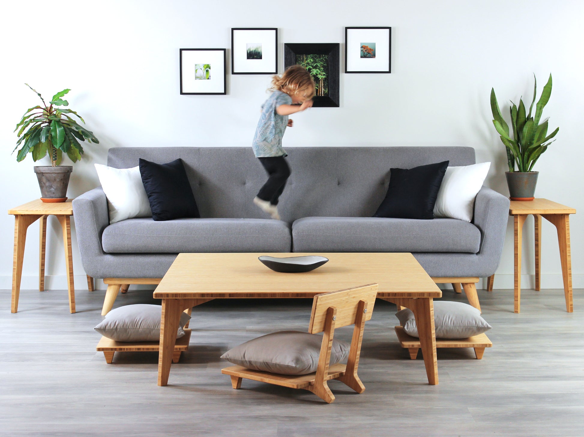 Large Square Low Table with a natural bamboo finish and midcentury modern design. Floor Chair Comfort  and two Floor Chair Posture with grey pillows are set at the table. Small black pottery vessel placed on table top. 

Japandi, minimalist, mid-century, Japanese inspired, modern, contemporary, clean lines, organic design, sustainable bamboo, renewable bamboo, solid bamboo, eco-friendly furniture, natural materials, natural-based finish