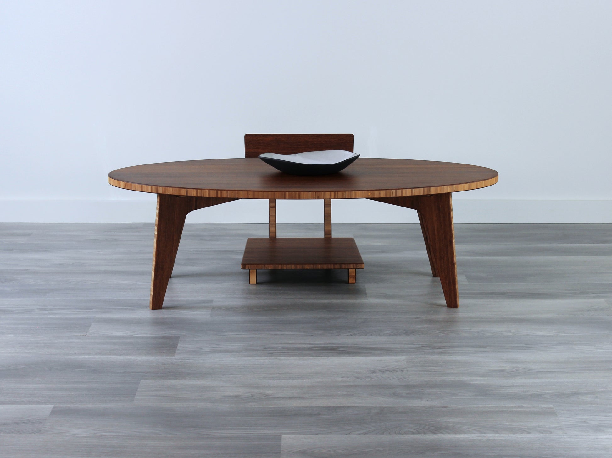 Oval LOW Table set with a chestnut bamboo finish and midcentury modern design. A Floor Chair Comfort is set at the table. Small black pottery vessel placed on table top. 

Japandi, minimalist, mid-century, Japanese inspired, modern, contemporary, clean lines, organic design, sustainable bamboo, renewable bamboo, solid bamboo, eco-friendly furniture, natural materials, natural-based finish
