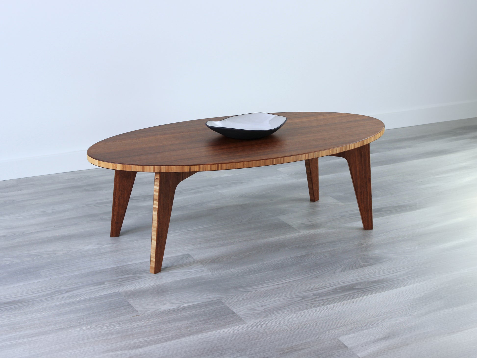 Oval LOW Table set with a chestnut bamboo finish and midcentury modern design. Small black pottery vessel placed on table top. 

Japandi, minimalist, mid-century, Japanese inspired, modern, contemporary, clean lines, organic design, sustainable bamboo, renewable bamboo, solid bamboo, eco-friendly furniture, natural materials, natural-based finish
