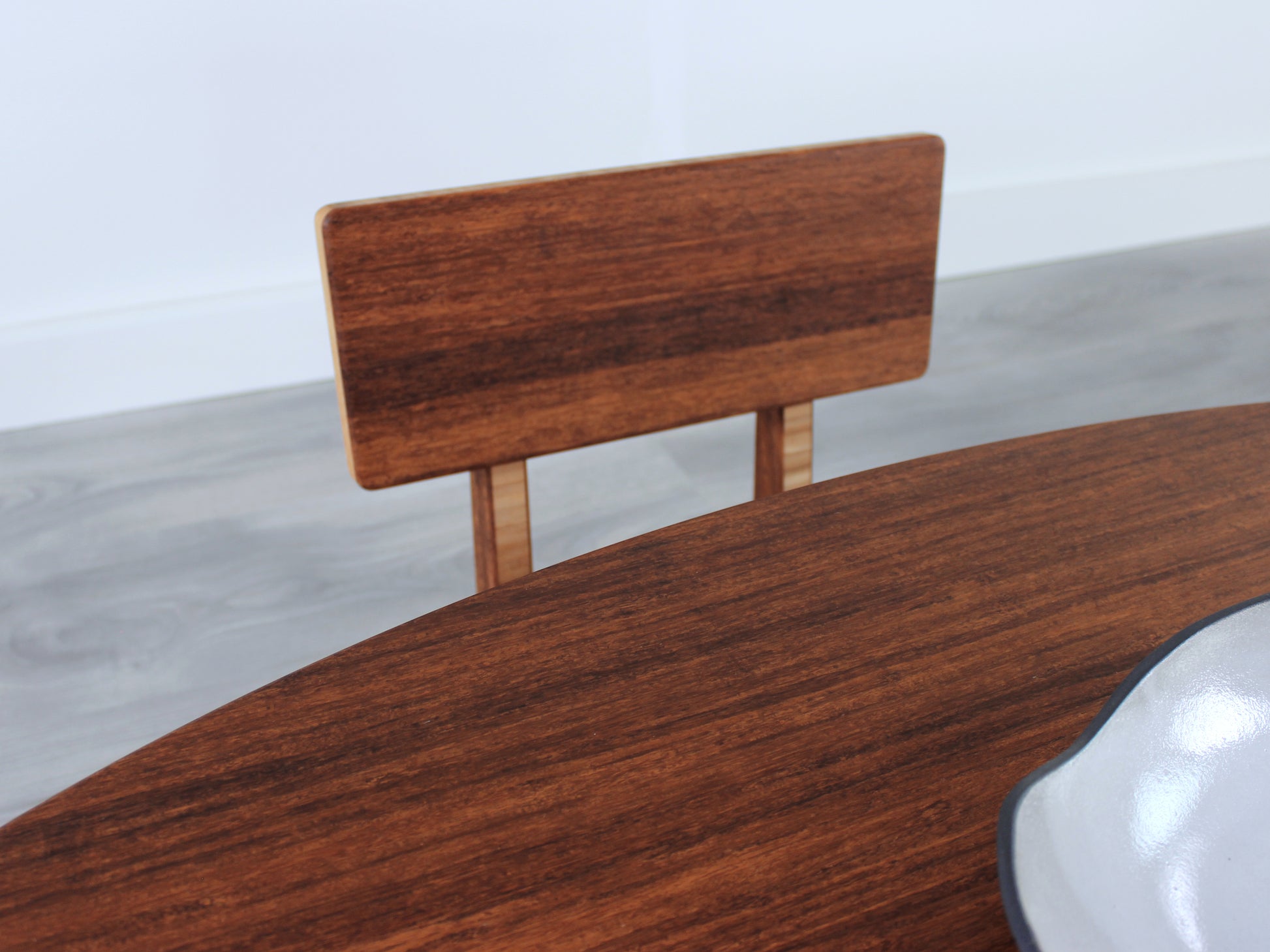 Oval LOW Table set with a chestnut bamboo finish and midcentury modern design. A Floor Chair Comfort is set at the table. Small black pottery vessel placed on table top. 

Japandi, minimalist, mid-century, Japanese inspired, modern, contemporary, clean lines, organic design, sustainable bamboo, renewable bamboo, solid bamboo, eco-friendly furniture, natural materials, natural-based finish

