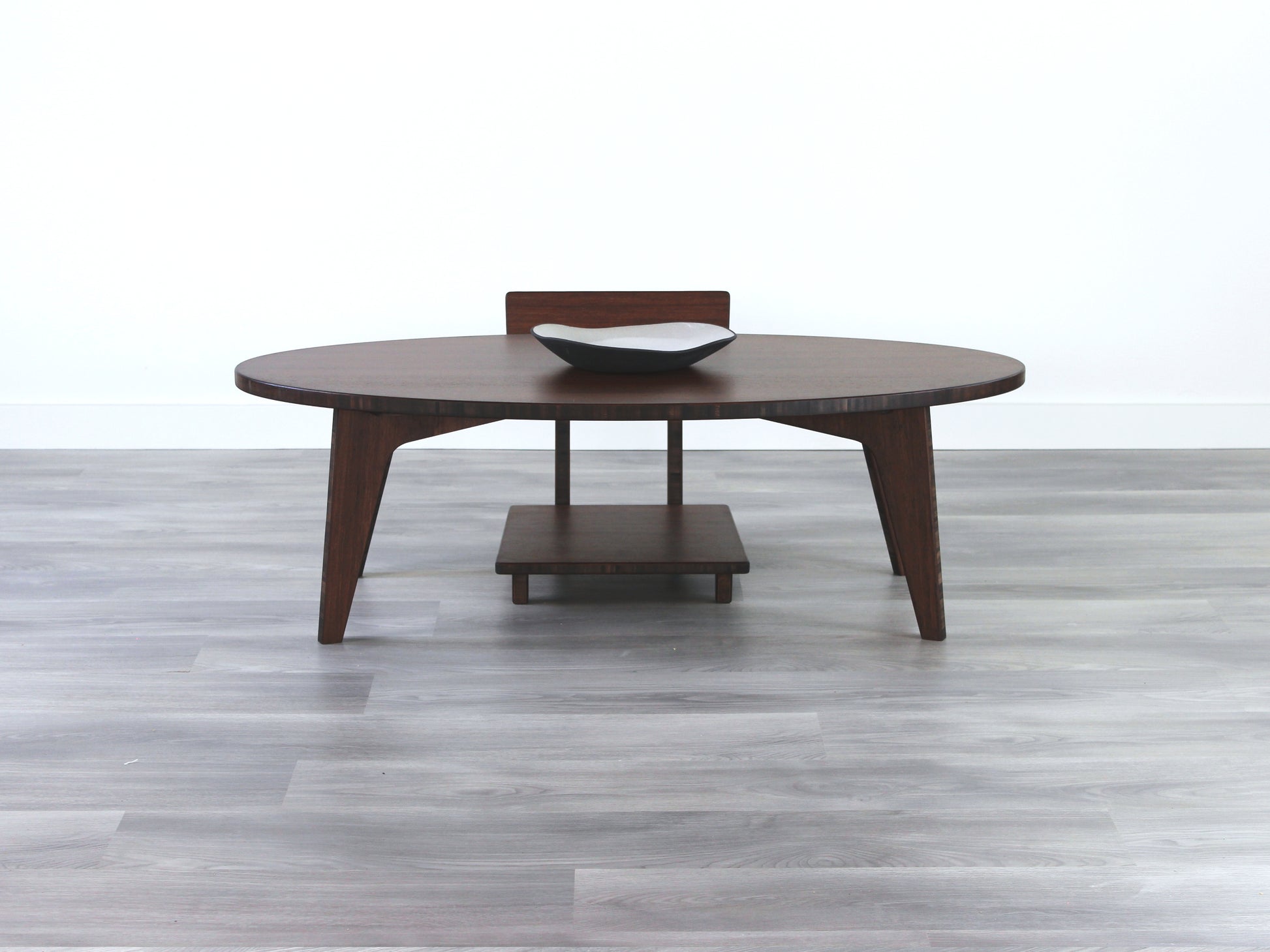 Oval LOW Table set with a walnut bamboo finish and midcentury modern design. A Floor Chair Comfort set at the table. Small black pottery vessel placed on table top. 

Japandi, minimalist, mid-century, Japanese inspired, modern, contemporary, clean lines, organic design, sustainable bamboo, renewable bamboo, solid bamboo, eco-friendly furniture, natural materials, natural-based finish