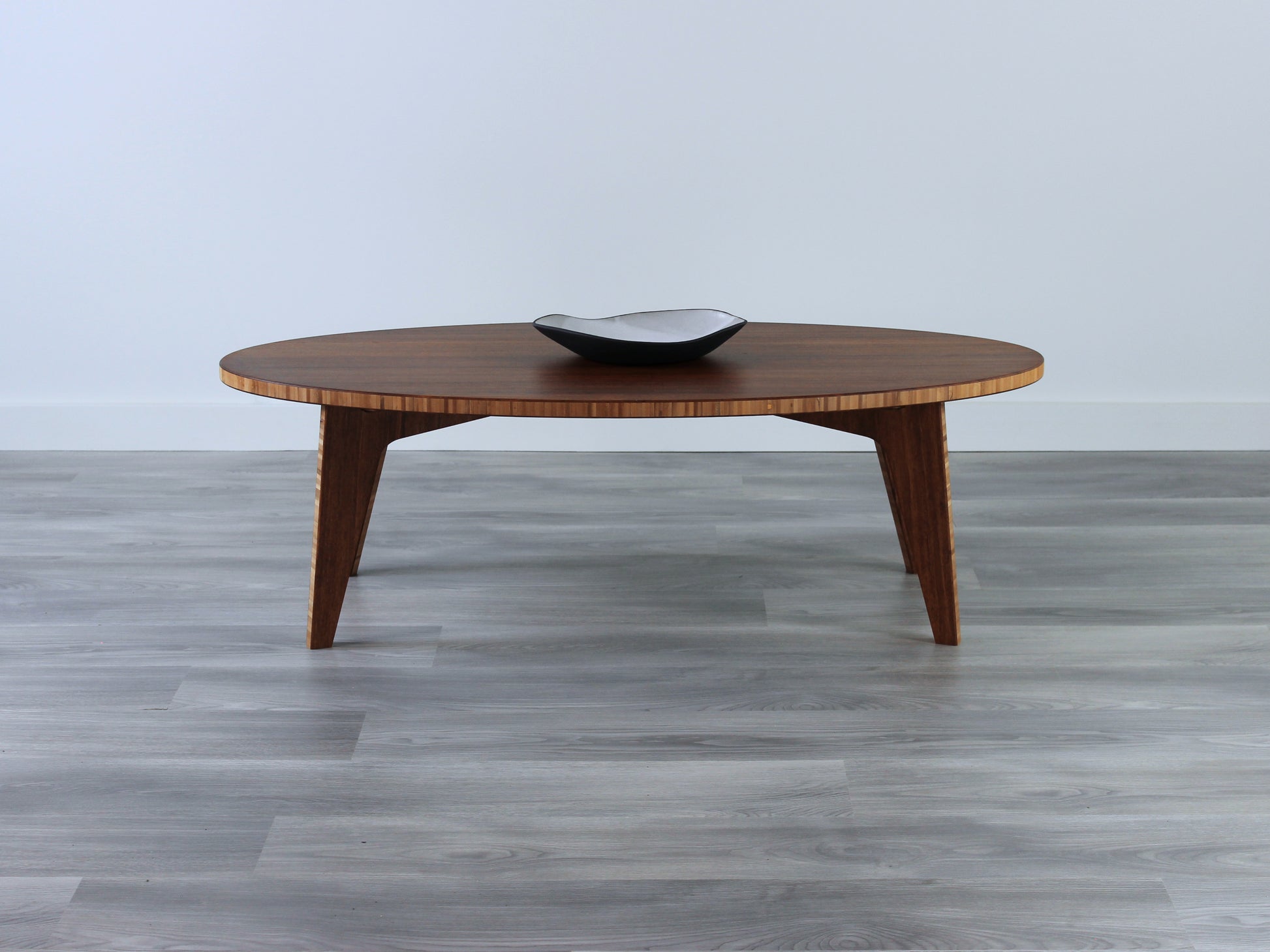 An oval-shaped bamboo table with a smooth, elongated surface and a warm finish. The table is placed on a grey floor, and it appears to have a small black and white pottery vessel on top.

kotatsu
floor dining table
floor table
japan coffee table
japan furniture
japan table
chabudai
contemporary
