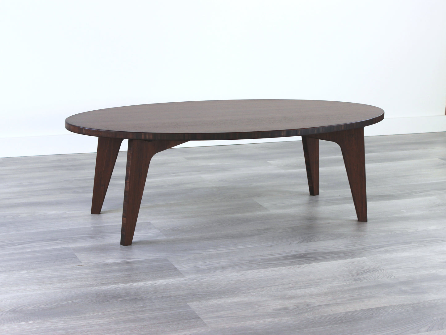 Oval bamboo table with a walnut color finish, featuring a Japandi style design, set on a grey floor with a white background. 

mid century modern low table
midcentury modern coffee table
floor table
japan coffee table
japan furniture
japan table
oval coffee table 
bamboo low table