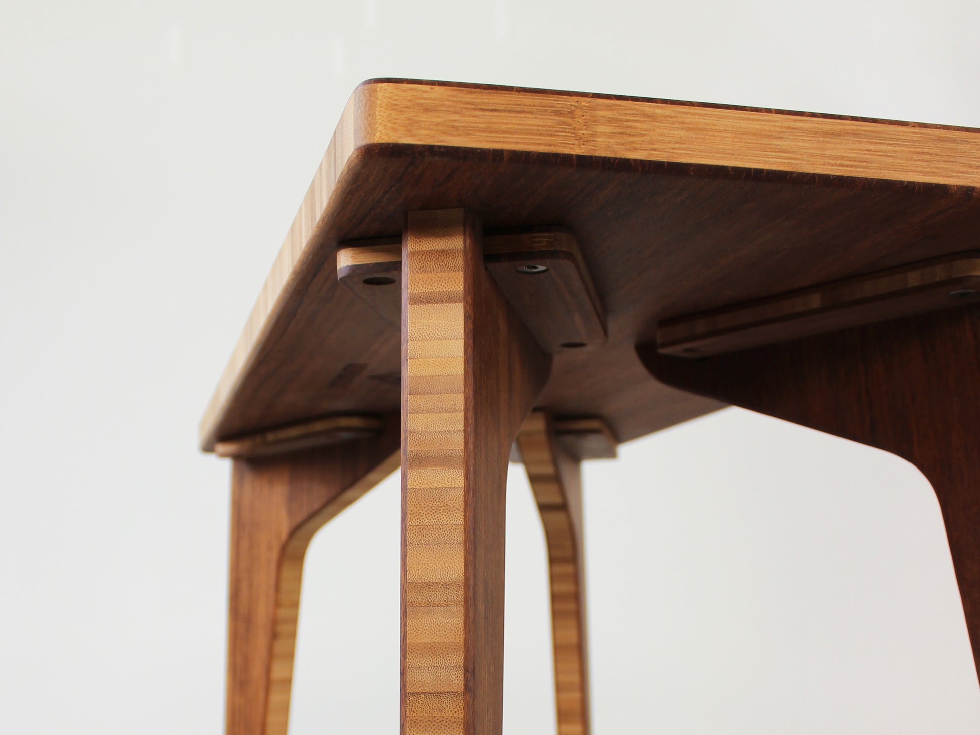 A rectangular side table with a chestnut finish bamboo top and legs, view of underside. Handmade bracket hardware, allows for leg removal/replacement. 
mid century
minimalist
chabudai
coffee table
side table
brackets 
removable hardware
