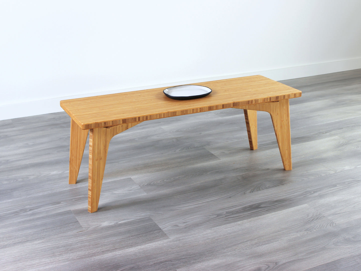 A small rectangular floor desk made of bamboo with a natural finish, small white and black pottery on the table face. All placed on a grey floor with a white wall in the background.
japanese furniture
japanese low table
mid century
minimalist
minimalist table
low desk 
tatami
