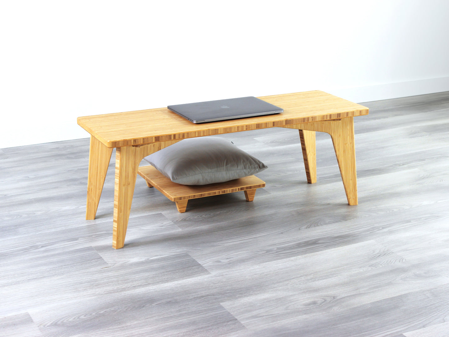 A small rectangular floor desk made of bamboo with a natural finish, a laptop on the table face with Floor Chair Posture set beneath. All placed on a grey floor with a white wall in the background.
japanese furniture
japanese low table
mid century
minimalist
minimalist table
low desk 
tatami