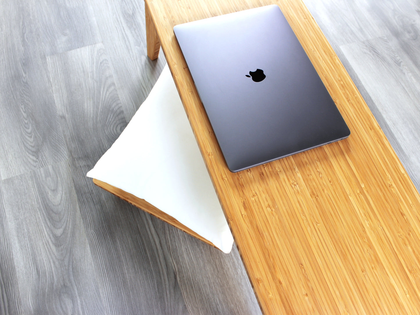 An overhead view of a small rectangular floor desk made of bamboo with a natural finish, a laptop on the table face with a Floor Chair Posture set beneath. All placed on a grey floor with a white wall in the background.
japanese furniture
japanese low table
mid century
minimalist
minimalist table
low desk 
tatami