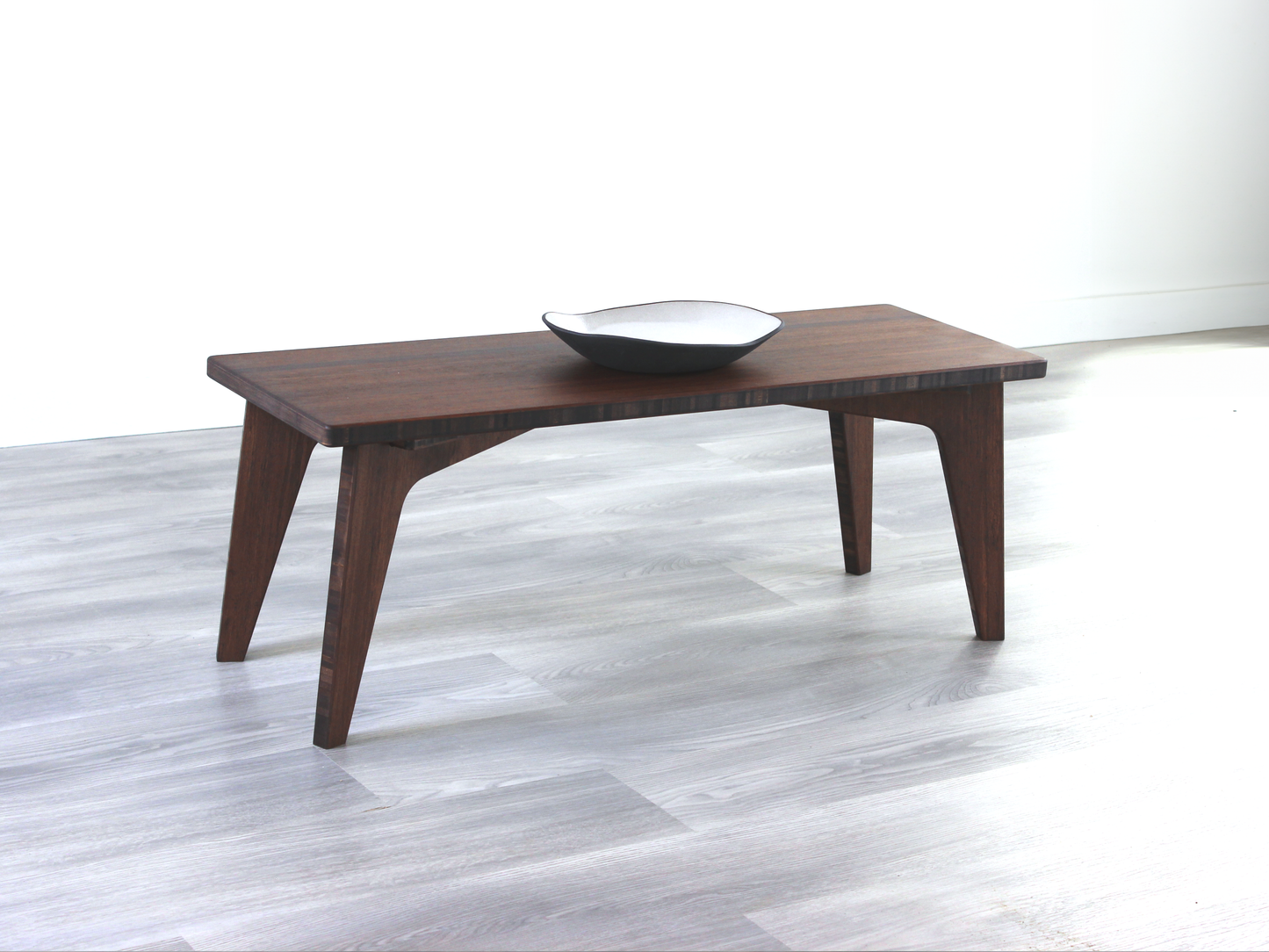 A small rectangular walnut finish bamboo floor desk accompanied by a black rectangular bowl on top. The desk is placed against a plain white background on a grey floor.
japanese low table
low desk 
minimilist 
modern 
contemporary design 