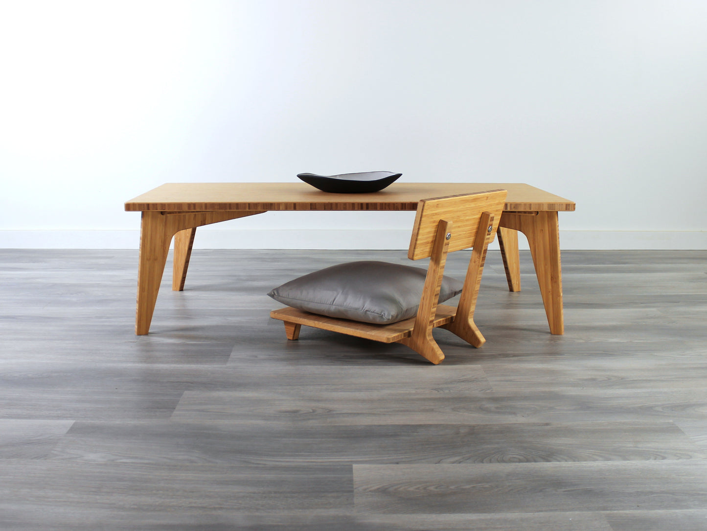 Small Rectangle Table Set - Chestnut, low table with Floor Chair Comfort set under with grey pillow. Set on a grey floor, against a white background. A small black pottery vessel is on the table top. 

low table, coffee table, dining table, floor desk, floor chair, floor seating, low dining table, chabudai, tatami, kotatsu, minimalist, minimalist table,
modern
