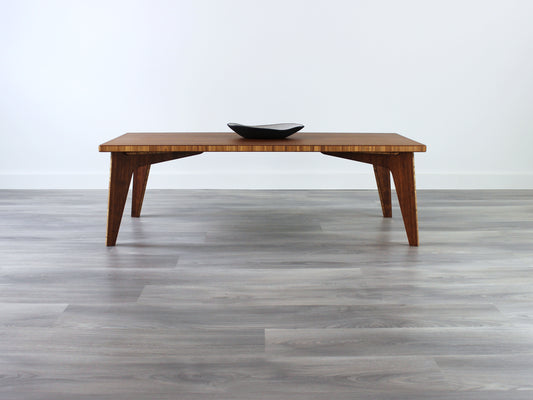 A small rectangular low table made of bamboo with a natural finish, placed on a grey floor with a white background. A small black pottery vessel is placed on the table top. 

japanese furniture
japanese low table
low coffee table
low dining table
low table
mid century
minimalist
minimalist table
modern
chabudai
