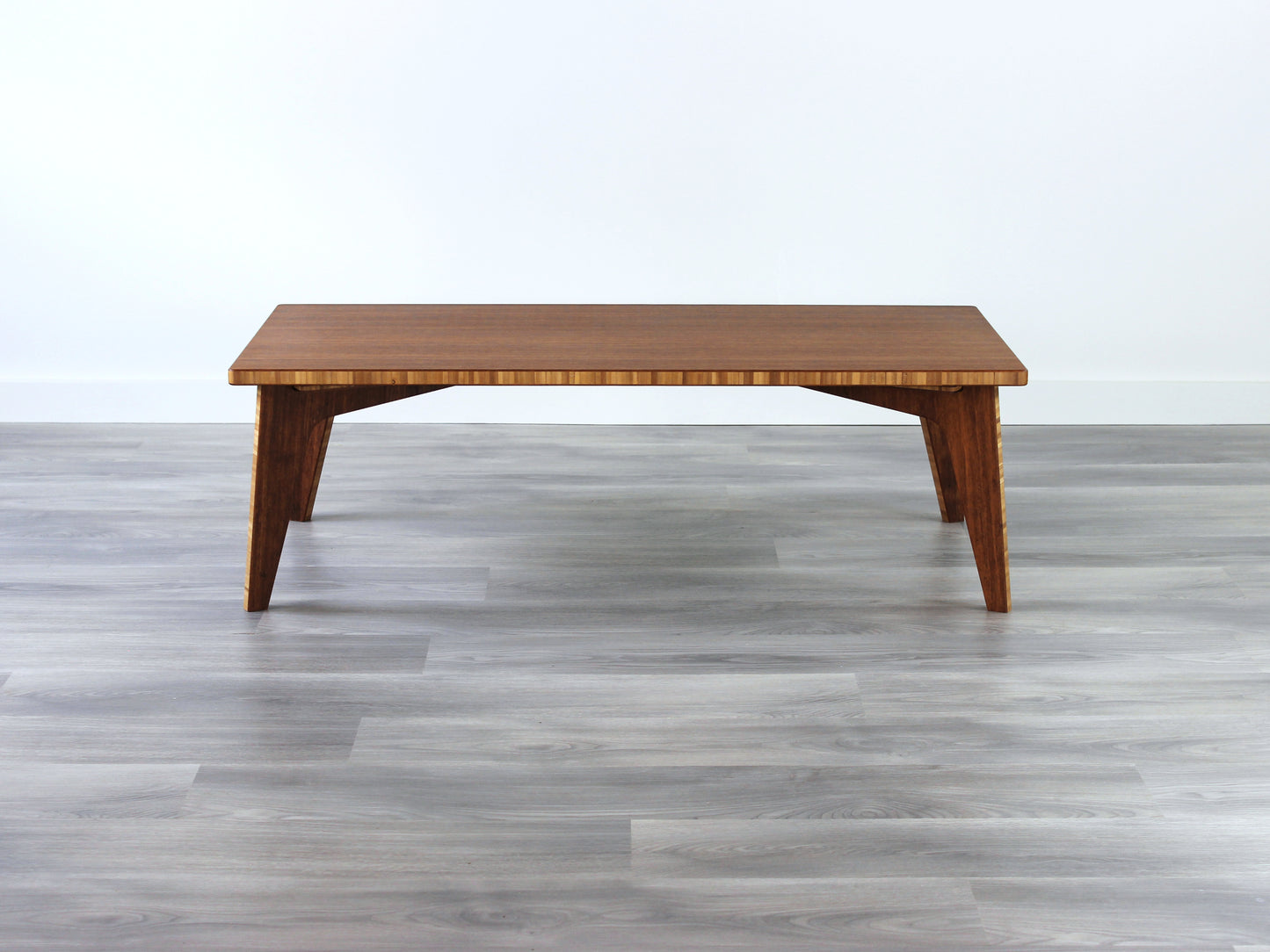 A small rectangular low table made of bamboo with a natural finish, placed on a grey floor with a white background. 

japanese furniture
japanese low table
low coffee table
low dining table
low table
mid century
minimalist
minimalist table
modern
chabudai
