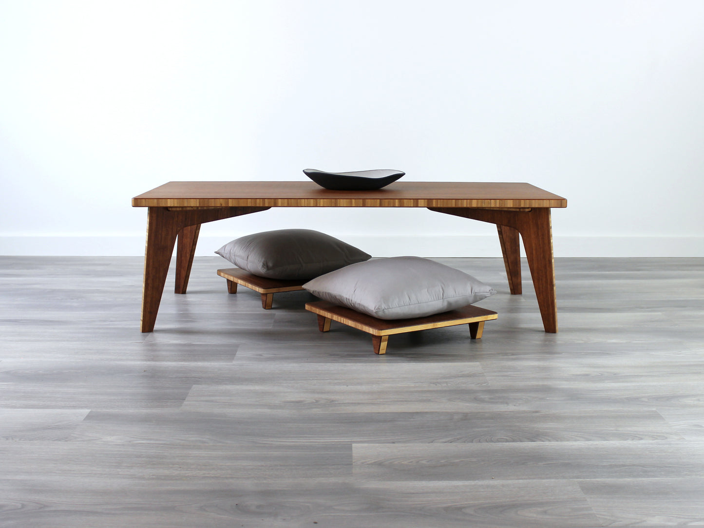 Small Rectangle Table Set- Chestnut, low table with two Floor Chair Posture set under with grey pillows. Set on a grey floor, against a white background. A small black pottery vessel is on the table top. 

low table, coffee table, dining table, floor desk, floor chair, floor seating, low dining table, chabudai, tatami, kotatsu, minimalist, minimalist table,
modern