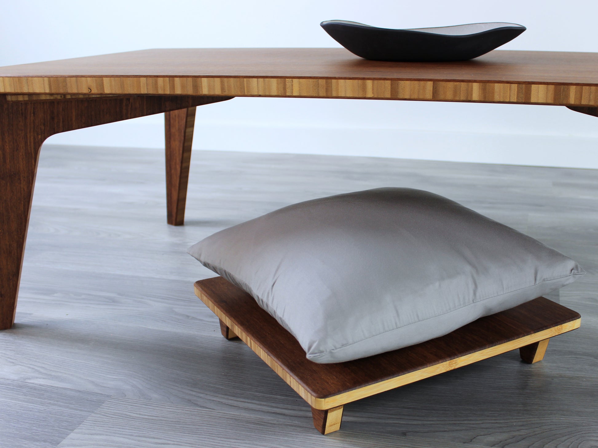 Small Rectangle Table Set - Chestnut, low table with Floor Chair Posture set under with grey pillow. Set on a grey floor, against a white background. A small black pottery vessel is on the table top. 

low table, coffee table, dining table, floor desk, floor chair, floor seating, low dining table, chabudai, tatami, kotatsu, minimalist, minimalist table,
modern