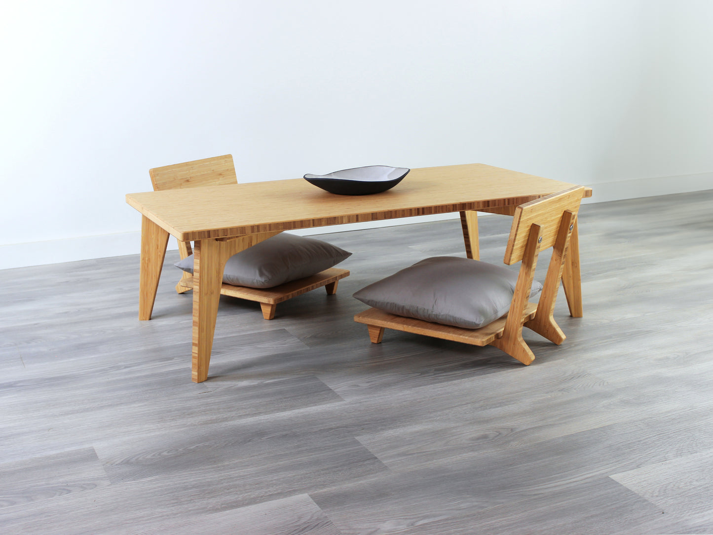 Small Rectangle Table Set - Natural, low table with Floor Chair Comfort set under with grey pillow. Set on a grey floor, against a white background. A small black pottery vessel is on the table top. 

low table, coffee table, dining table, floor desk, floor chair, floor seating, low dining table, chabudai, tatami, kotatsu, minimalist, minimalist table,
modern