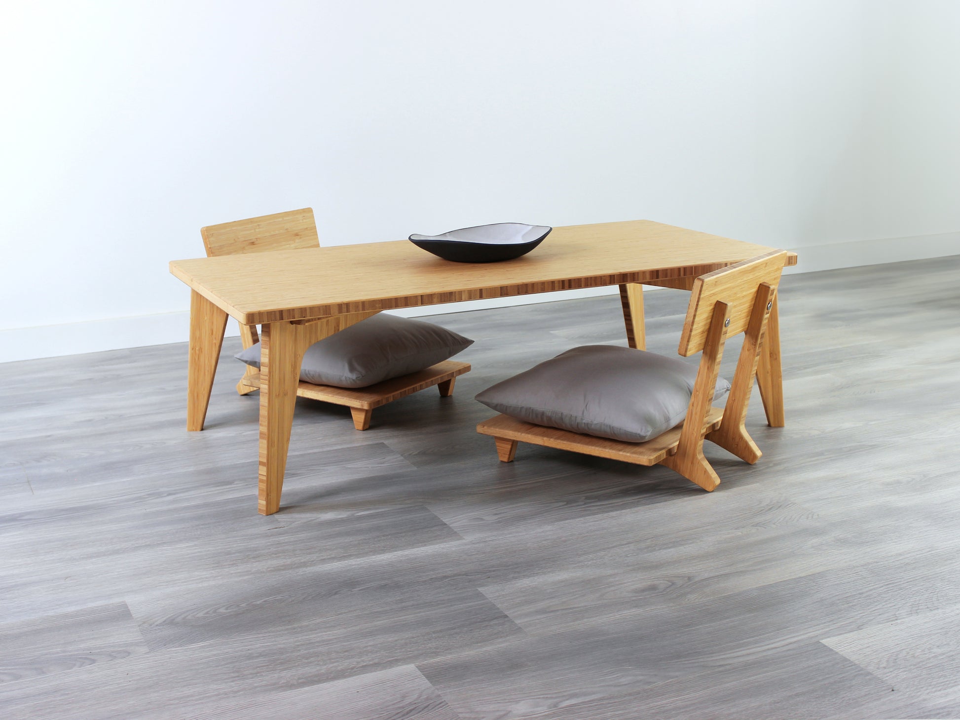 Small Rectangle Table Set - Natural, low table with Floor Chair Comfort set under with grey pillow. Set on a grey floor, against a white background. A small black pottery vessel is on the table top. 

low table, coffee table, dining table, floor desk, floor chair, floor seating, low dining table, chabudai, tatami, kotatsu, minimalist, minimalist table,
modern