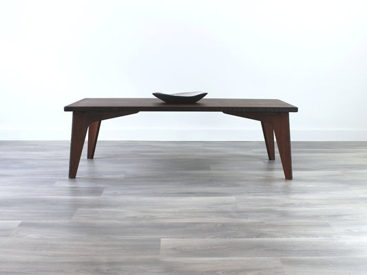 A rectangular low table made of bamboo with a walnut finish, placed on a grey floor, designed for multi-functional use in living spaces. Small black pottery vessel on table top. 

japanese furniture
japanese low table
low coffee table
low dining table
low table
mid century
minimalist
minimalist table
modern