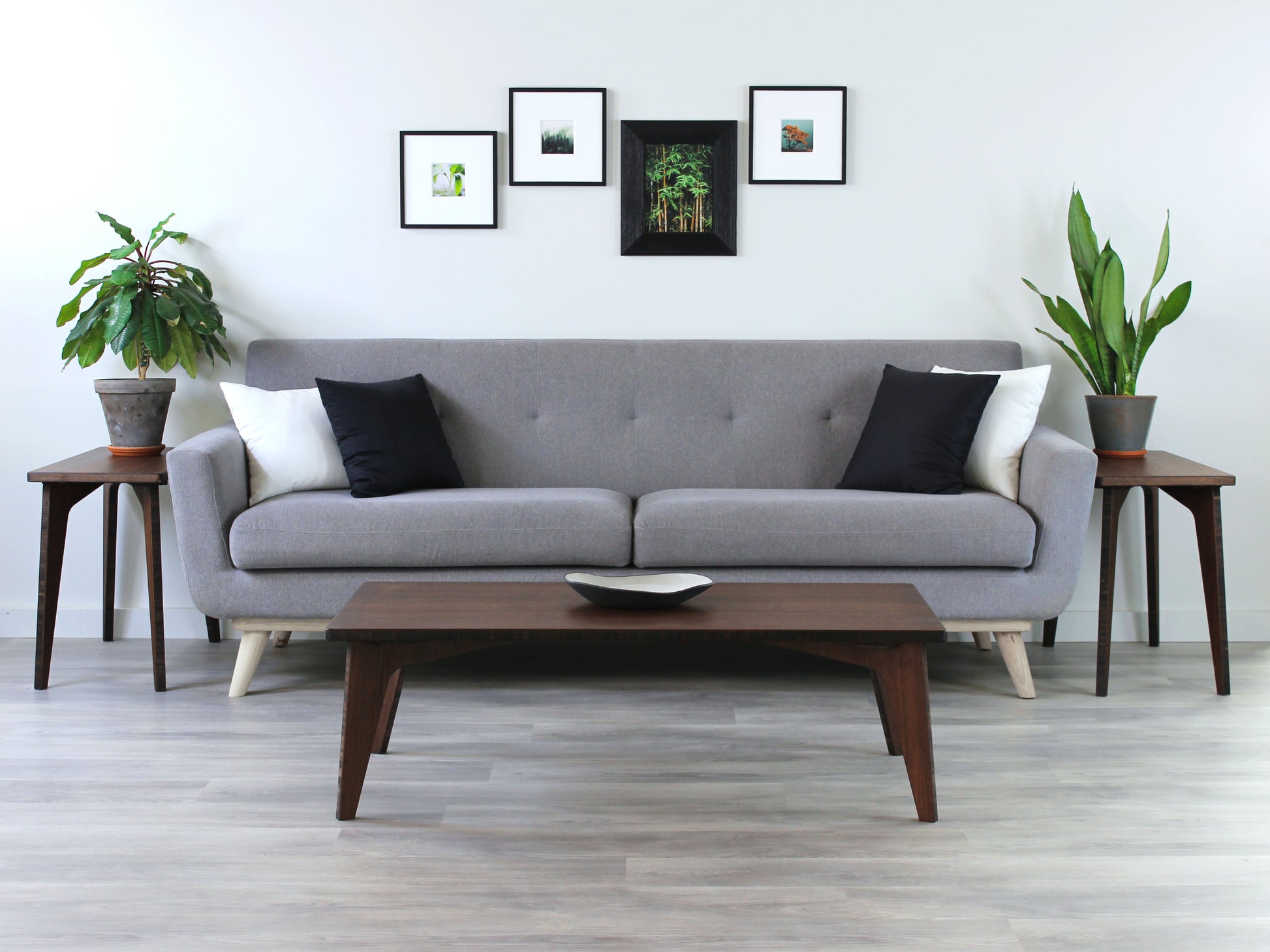 A rectangular low table made of bamboo with a walnut finish, placed on a grey floor, designed for multi-functional use in living spaces. Small black pottery vessel on table top. Set in a living room setting with a grey couch and two Side Tables with houseplants. 

japanese furniture
japanese low table
low coffee table
low dining table
low table
mid century
minimalist
minimalist table
modern
