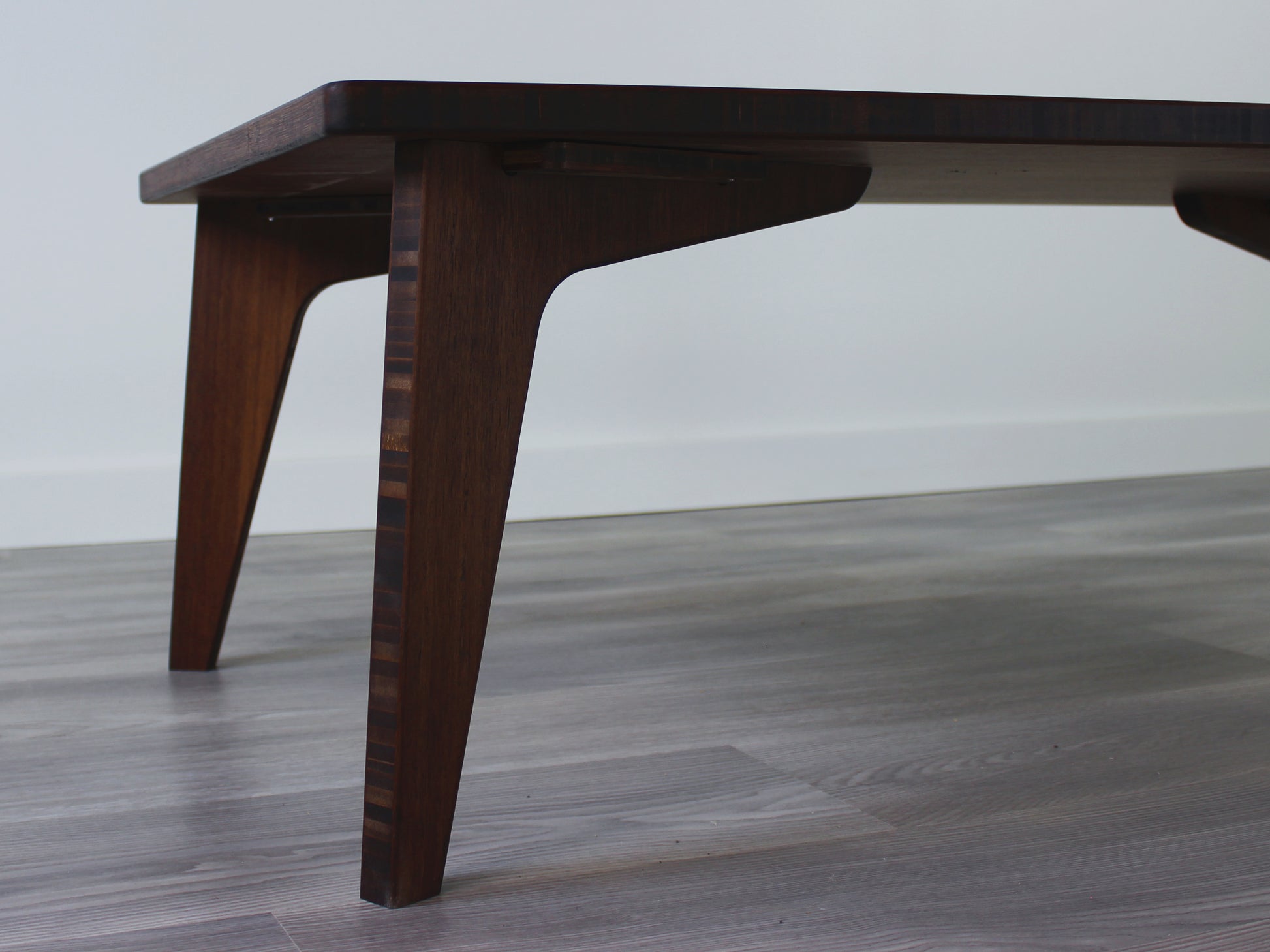 A rectangular low table made of bamboo with a walnut finish, placed on a grey floor, designed for multi-functional use in living spaces. 

japanese furniture
japanese low table
low coffee table
low dining table
low table
mid century
minimalist
minimalist table
modern