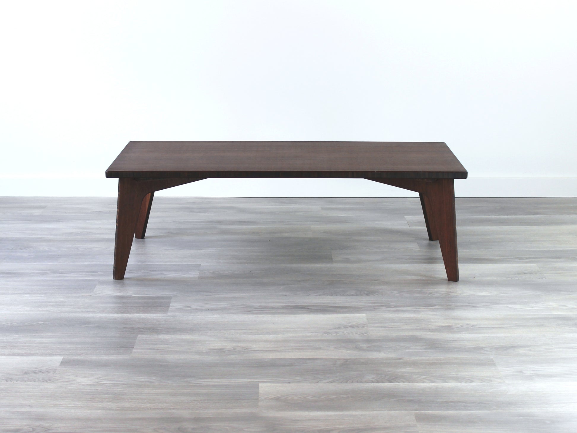 A rectangular low table made of bamboo with a walnut finish, placed on a grey floor, designed for multi-functional use in living spaces.  

japanese furniture
japanese low table
low coffee table
low dining table
low table
mid century
minimalist
minimalist table
modern