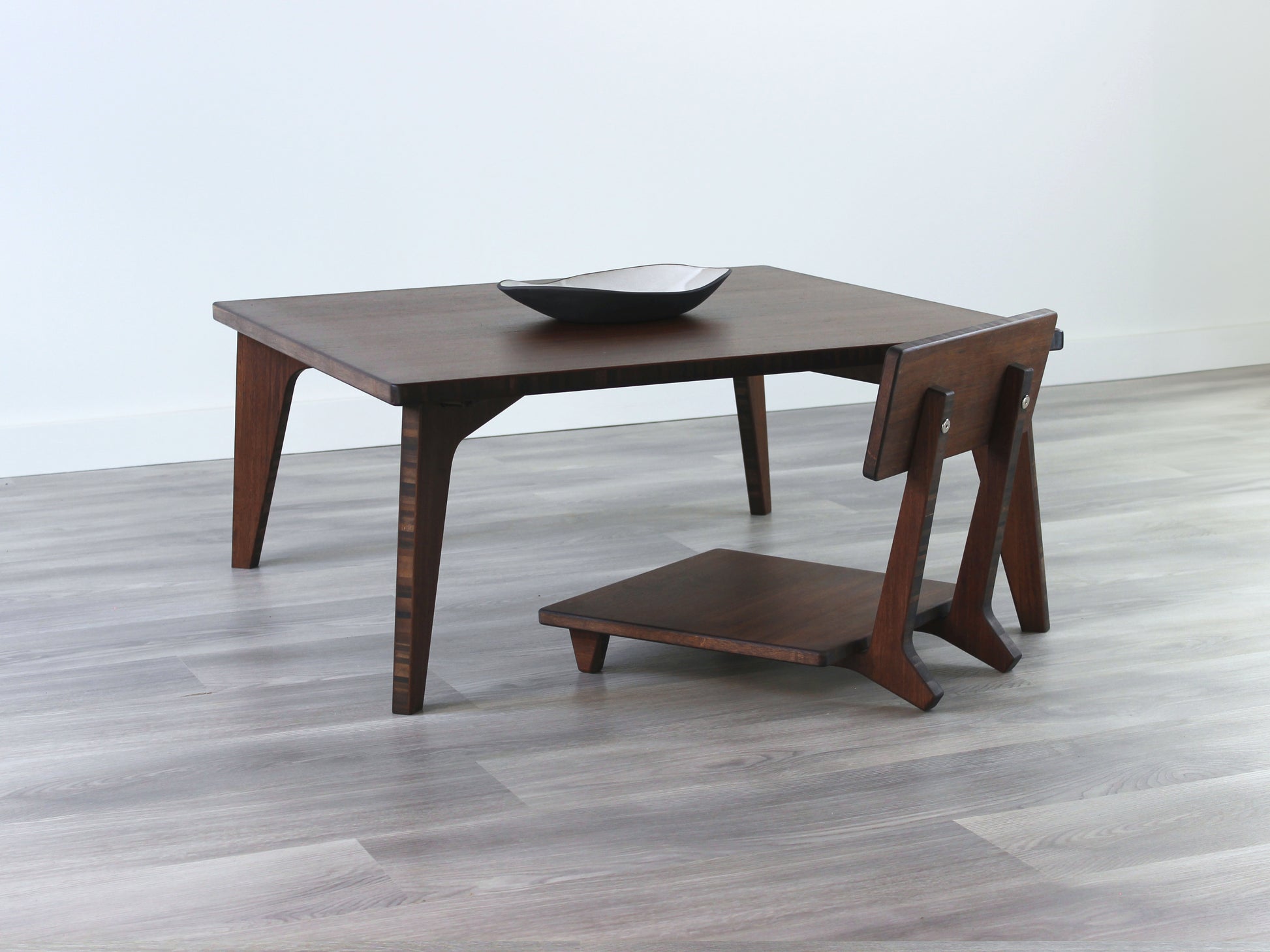 Small Square Table Set in walnut finish. A Floor Chair Comfort is  placed below. A small black pottery vessel is placed on top of the table. 

sustainable bamboo, renewable bamboo, solid bamboo, eco-friendly furniture, zero-waste, carbon neutral, natural materials, natural-based finish, repairable furniture