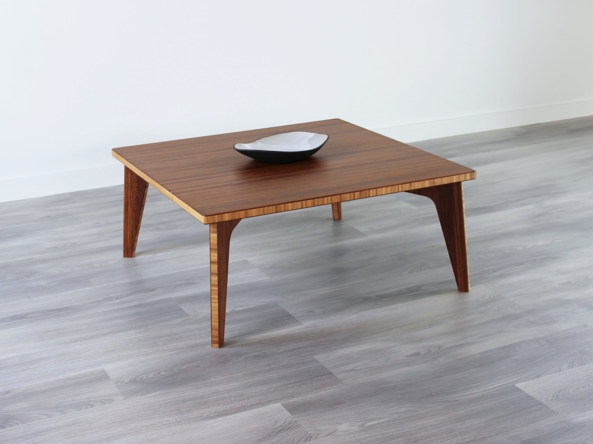 Small Square Table with chestnut bamboo finish, featuring a small black and white pottery vessel placed on top. Grey flooring with a white background. 

mid century modern low table
midcentury modern coffee table
floor table
japan coffee table
japan furniture
japan table
small coffee table 
bamboo low table