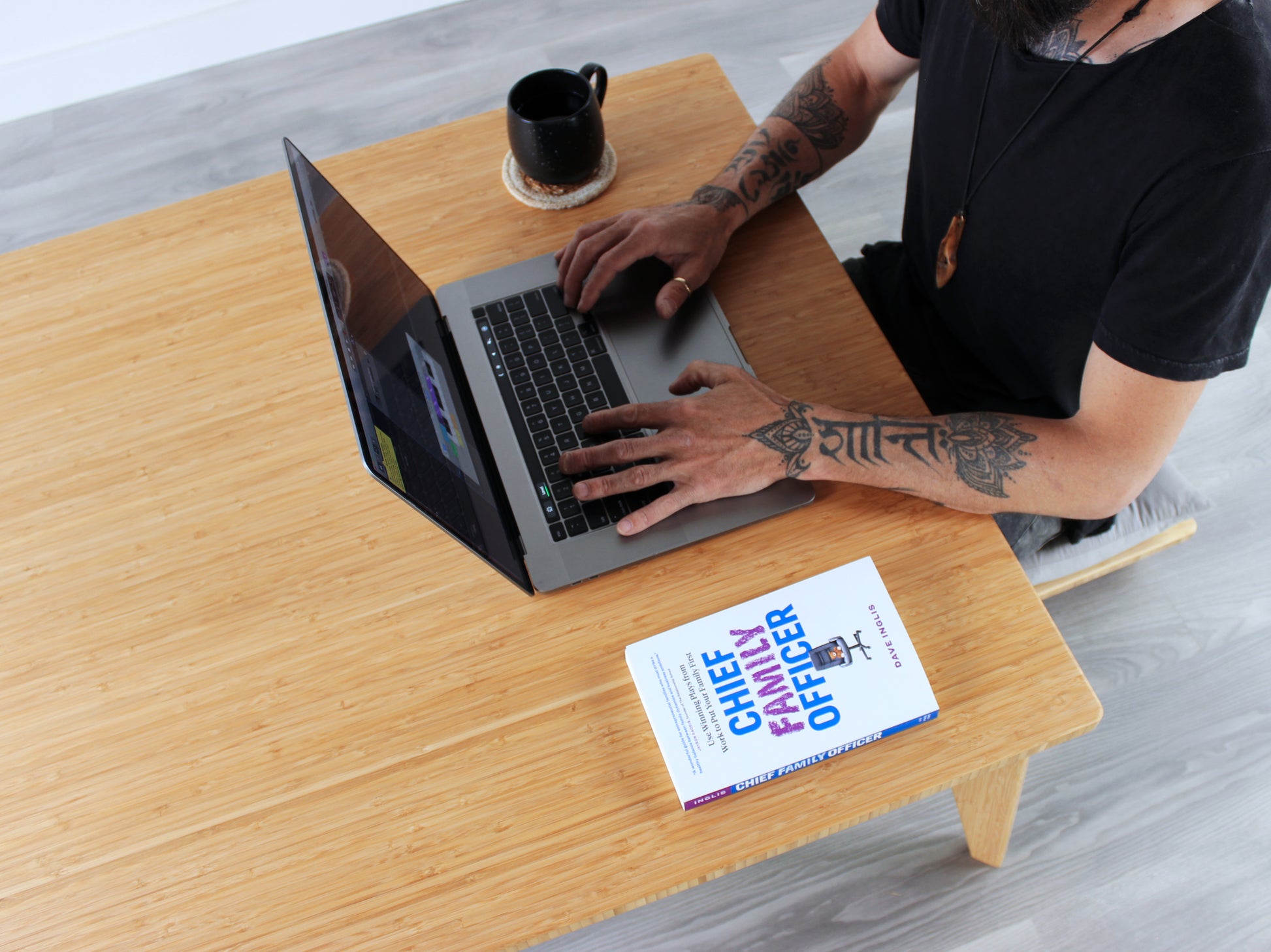 Person sitting at Small Square Table in natural bamboo, working on a lap top. Black coffee mug and white book placed on table top. 

mid century modern low table
midcentury modern coffee table
floor table
japan coffee table
japan furniture
japan table
small coffee table 
bamboo low table