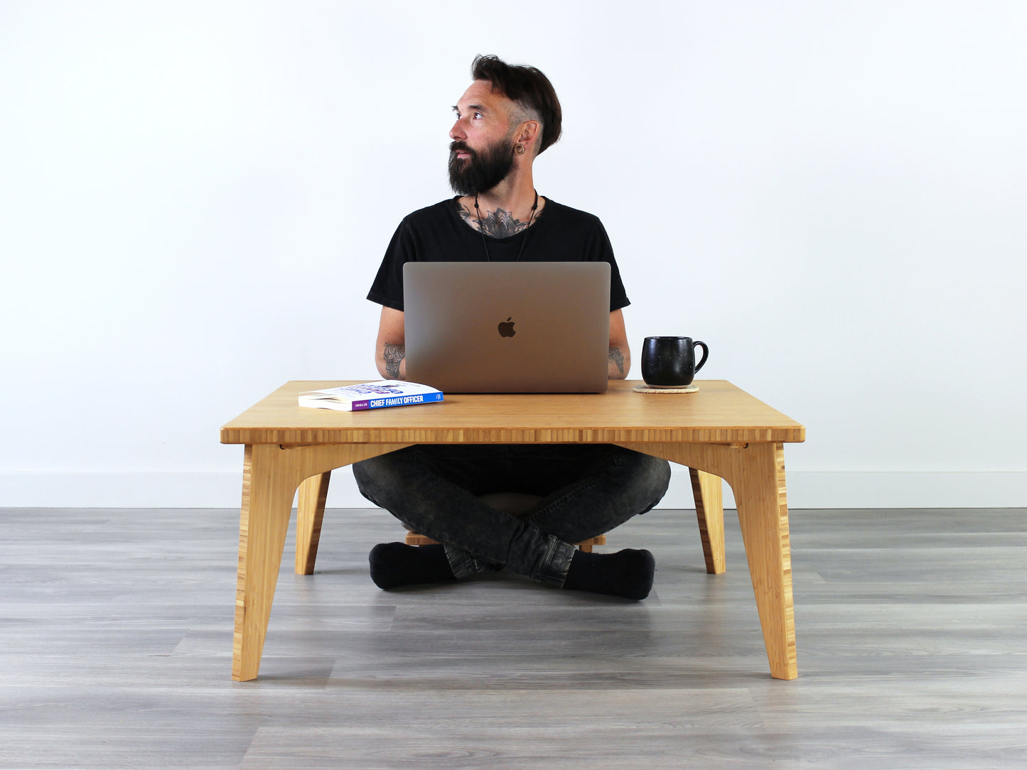 Small Square Table Set in natural finish. A person sits at the table in a black shirt, working on a laptop.A black coffee mug is placed on top of the table. 

sustainable bamboo, renewable bamboo, solid bamboo, eco-friendly furniture, zero-waste, carbon neutral, natural materials, natural-based finish, repairable furniture