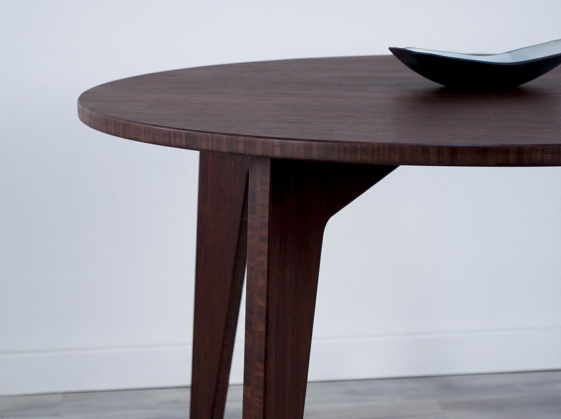 Walnut bamboo dining table on a white background with black bowl on top