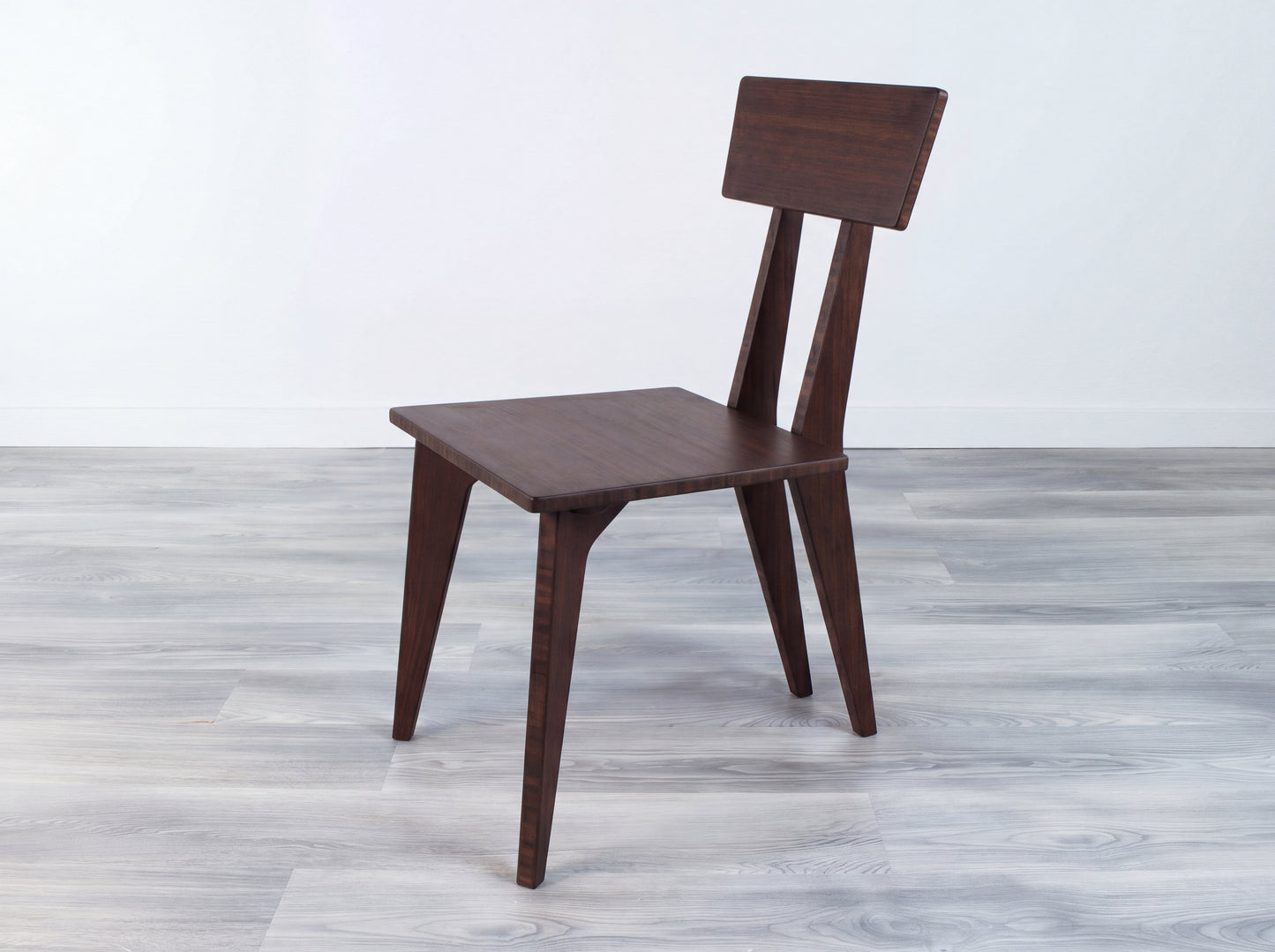 Bamboo chair on a gray wooden floor with a white wall background