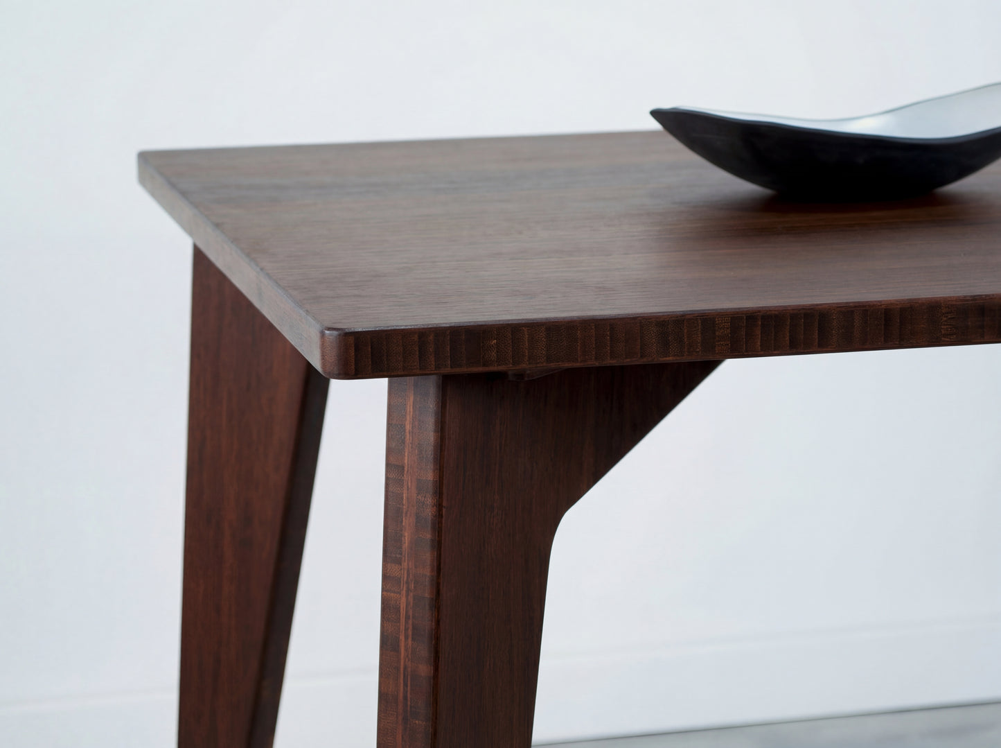 Bamboo dining table with a black bowl on a white background