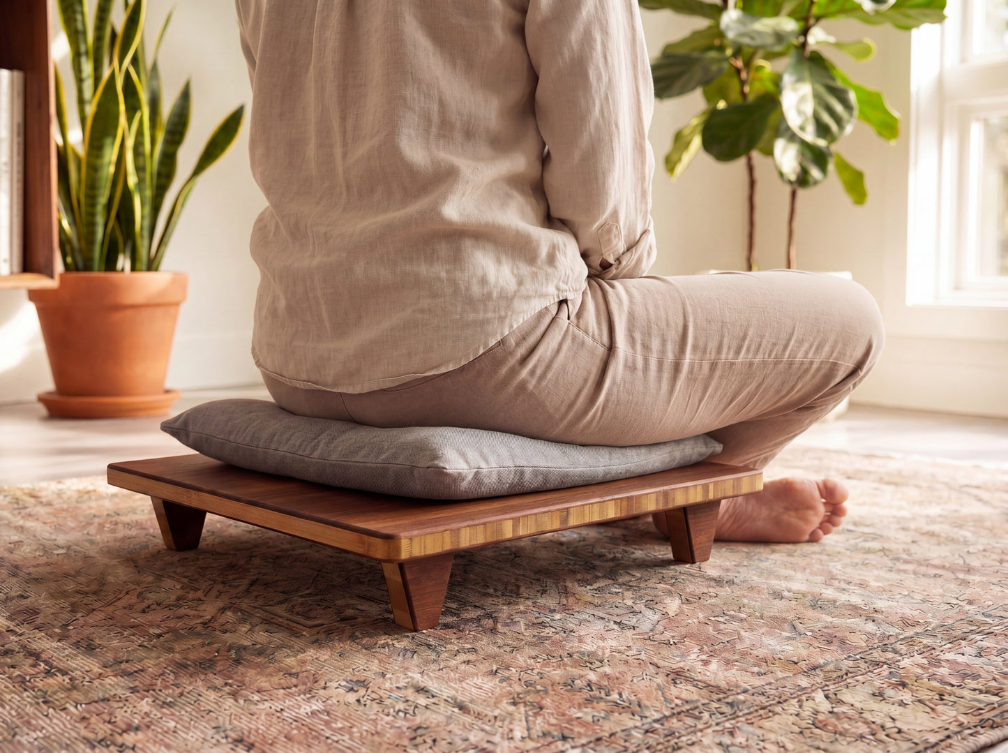 Person sitting on a bamboo meditation bench with cushion in a home setting.

Meditation Chair 
Japanese Tea Table 
Kotatsu
low chair
posture support 
ergonomic 
minimilist 

