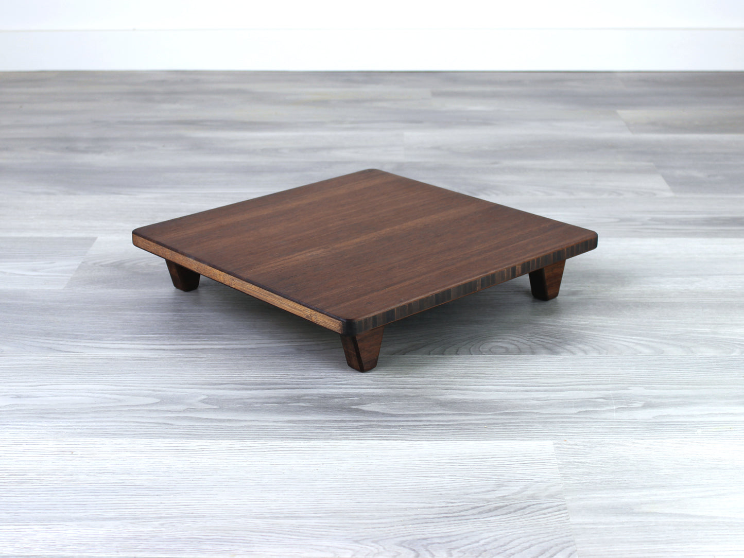 Walnut Floor Chair Posture, placed on a grey floor and a white wall background. 

Meditation Chair 
Japanese Tea Table 
Kotatsu
low chair
posture support 
ergonomic 
minimilist
