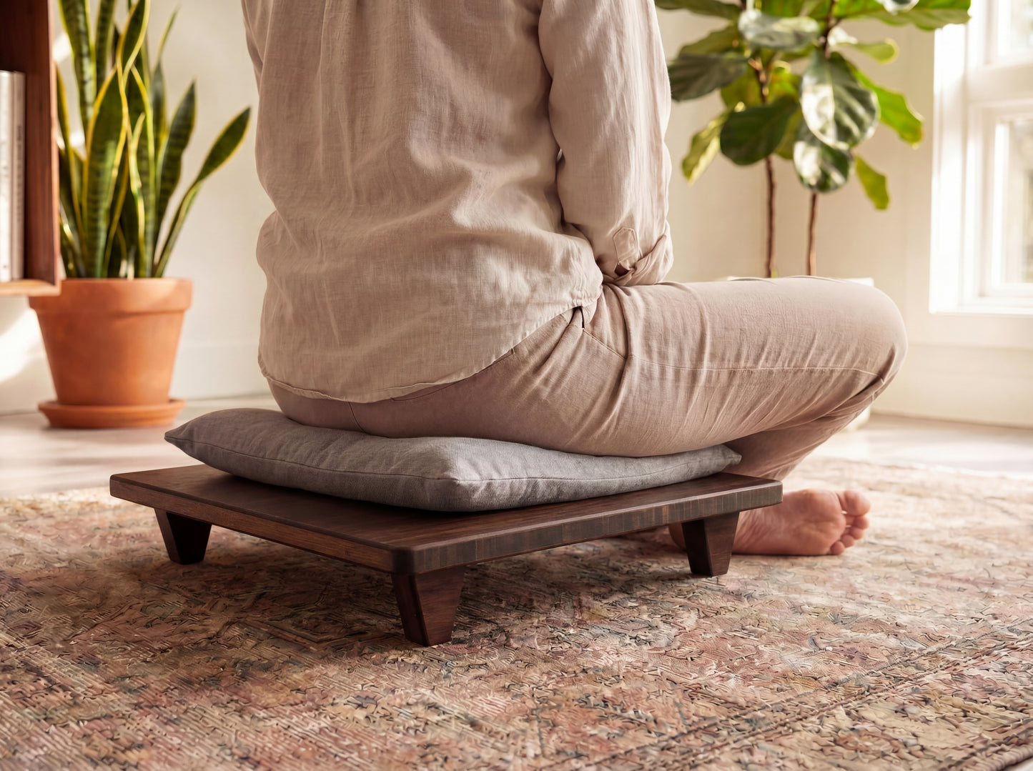 Person sitting on a bamboo meditation platform with cushion in a home setting.

Meditation Chair 
Japanese Tea Table 
Kotatsu
low chair
posture support 
ergonomic 
minimilist 