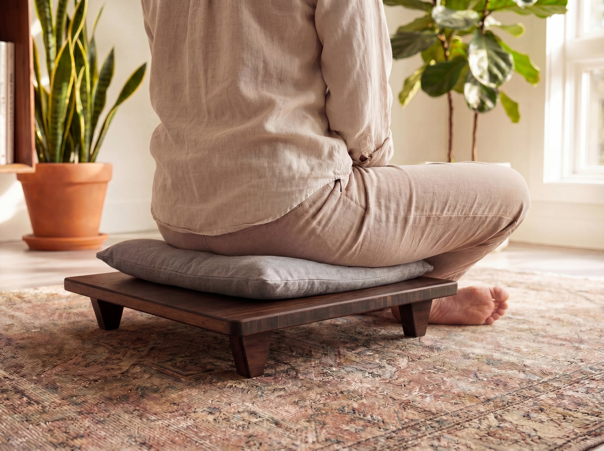 Person sitting on a bamboo meditation platform with cushion in a home setting.

Meditation Chair 
Japanese Tea Table 
Kotatsu
low chair
posture support 
ergonomic 
minimilist 
