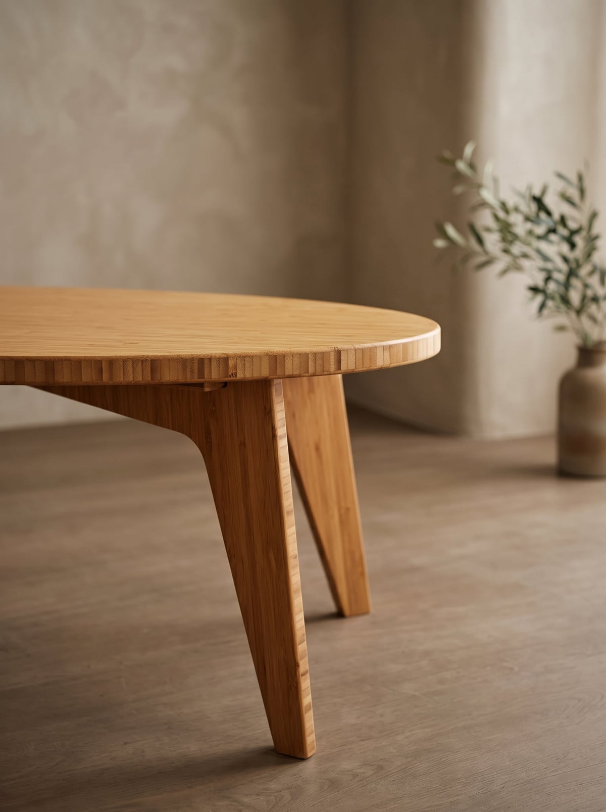 A close-up of a round oval solid bamboo Reforest table.