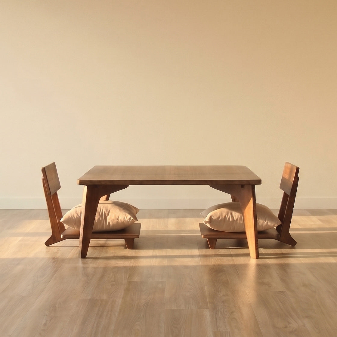 Reforest low bamboo table set with two seats with cushions on top in a window lit open space.