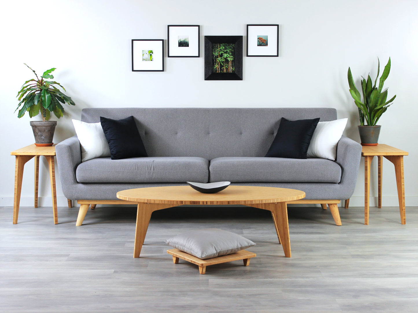 Oval bamboo table with a natural color finish, featuring a Japandi style design, set on a grey floor with a white background. Set in a living room area, a grey couch and side tables with houseplants. A small black pottery vessel is placed on the table top. 

mid century modern low table
midcentury modern coffee table
floor table
japan coffee table
japan furniture
japan table
oval coffee table 
bamboo low table